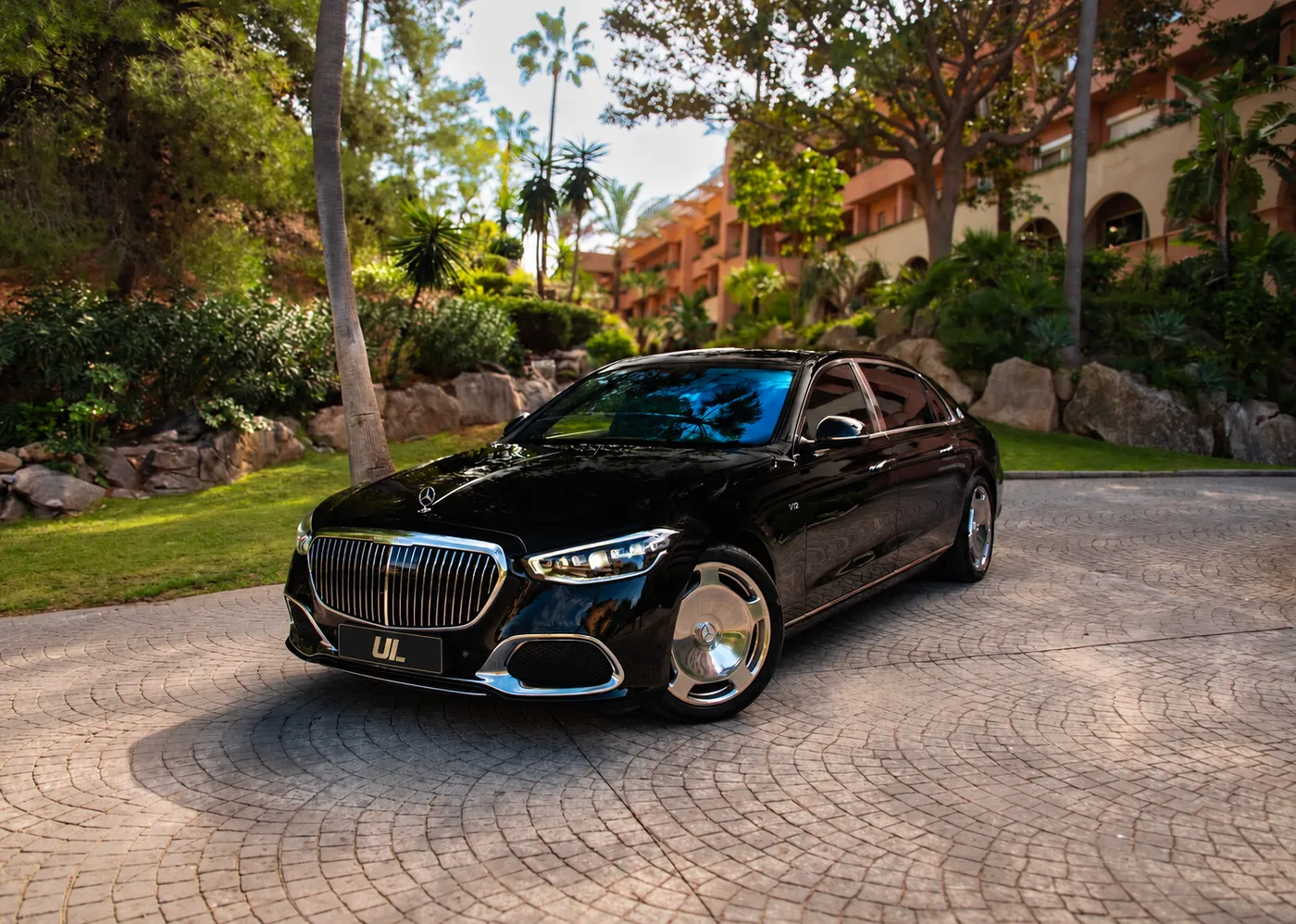 Black Mercedes-Maybach S 680 viewed from the front and side on a landscaped driveway.